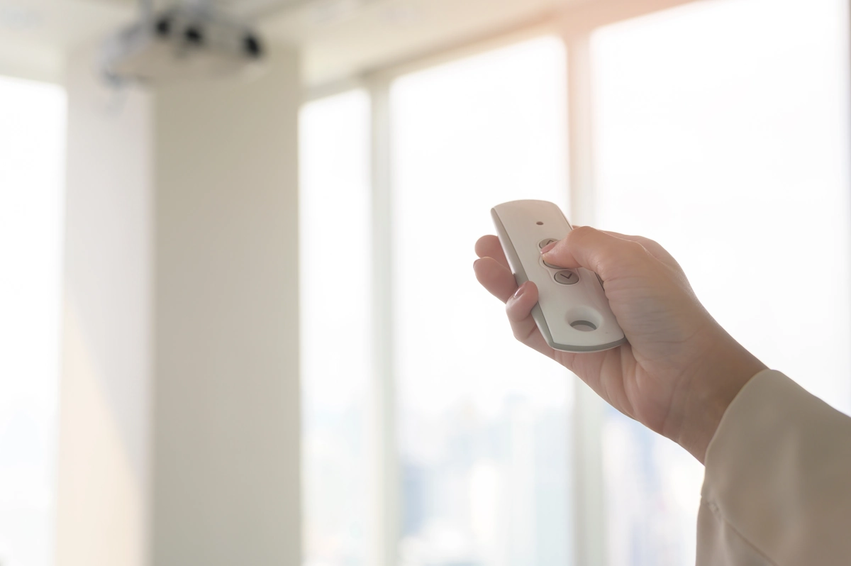 Une personne qui ouvre une fenêtre avec une télécommande