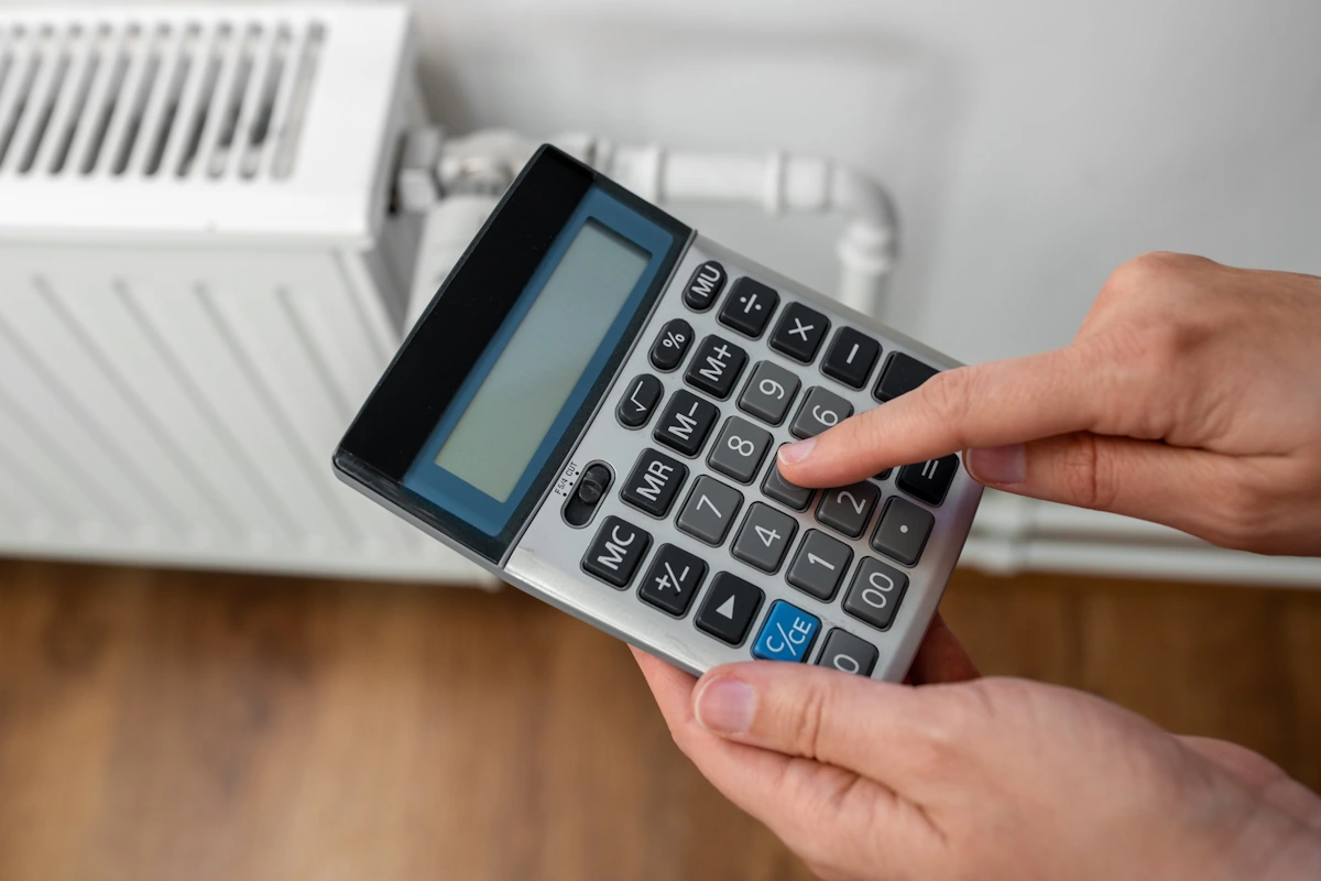 Une personne qui calcule la puissance totale de chauffage électrique d'une pièce