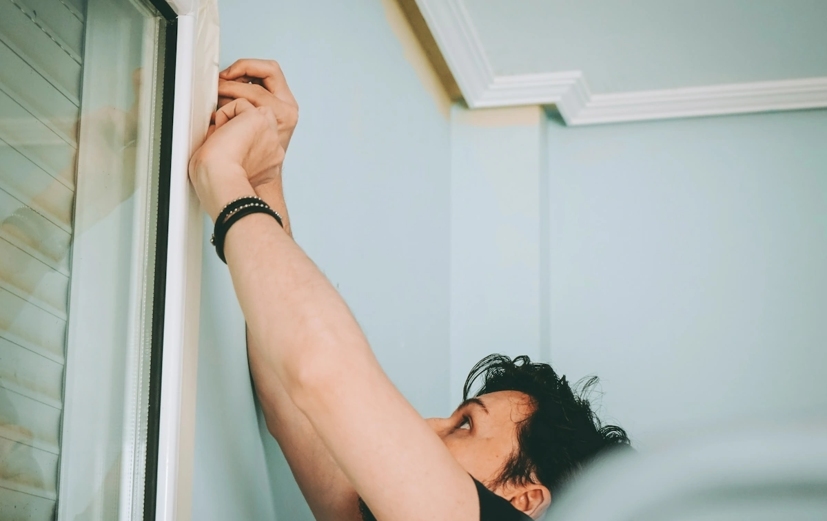 Une personne qui essaie d'ouvrir une fenêtre en hauteur